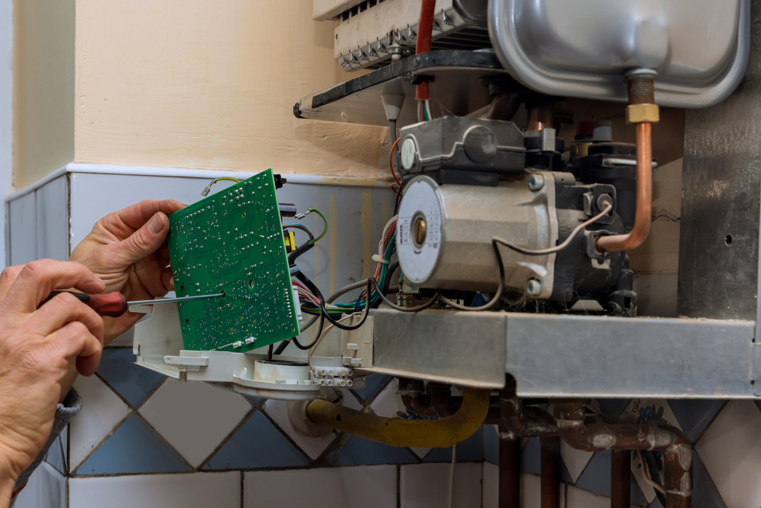 Technician worker looking inside gas heater trying to fix on the problem